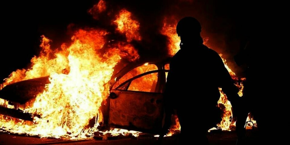 OPPTØYER: En politibil ble påtent av rasende demonstranter. Det skjedde i Ferguson i USA natt til tirsdag.