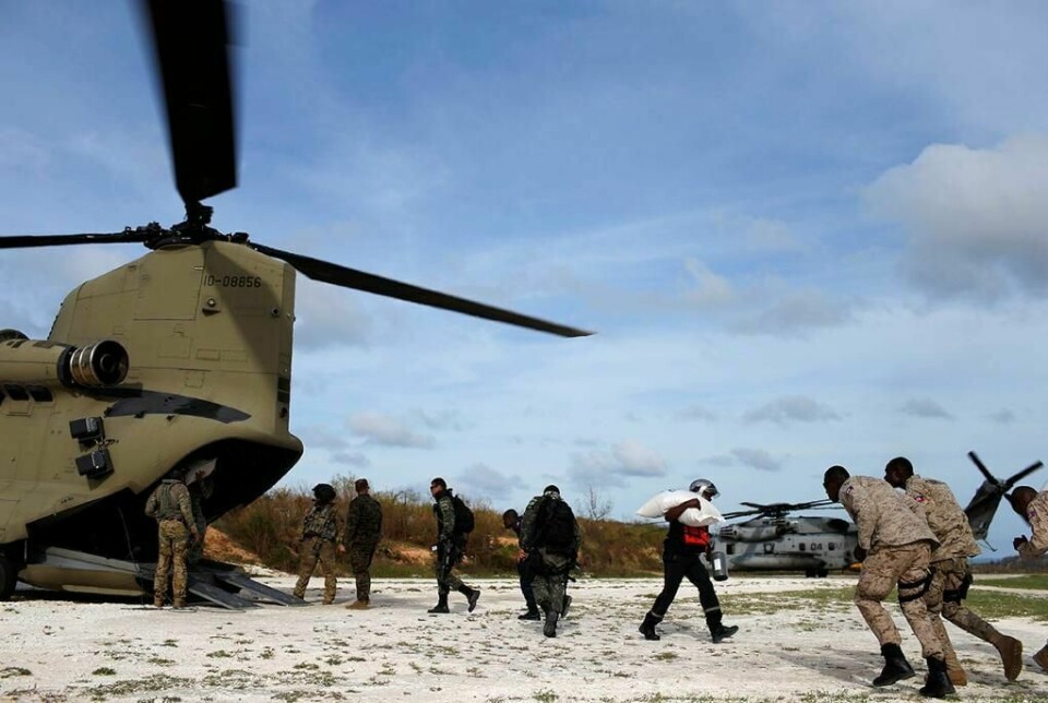 HJELP: Orkanen Matthew har knust deler av Haiti. 350.000 mennesker trenger hjelp. Mange mangler mat og vann. Helikoptre frakter nødhjelp ut til folk. Her bærer folk nødhjelp ut av et helikopter i byen Jeremie.