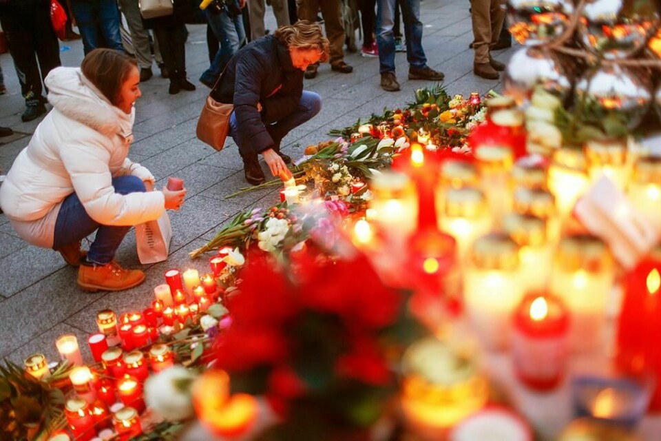 SØRGER: Folk legger ned lys og blomster ved julemarkedet i Berlin. 12 ble drept i et angrep her mandag.