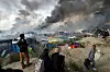 REVET: Røyk stiger opp fra brennende telt og skur i Calais 26. oktober. I mange år har folk bodd i leiren «Jungelen».