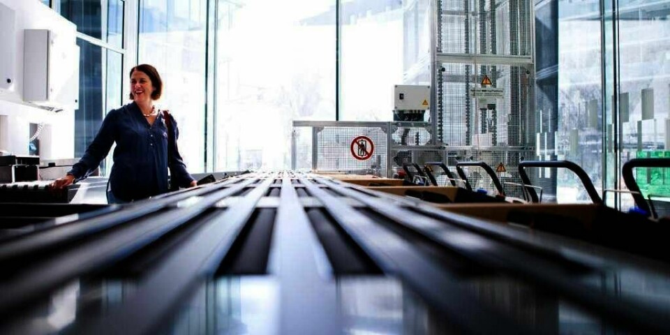 MODERNE: Lørenskog får nytt og moderne bibliotek. Ved dette båndet tar roboter imot bøkene du vil levere. Så sorterer robotene bøkene. De sender bøkene til rette etasje og hylle. Biblioteksjef Berit Bjørklid sjekker det nye anlegget.
