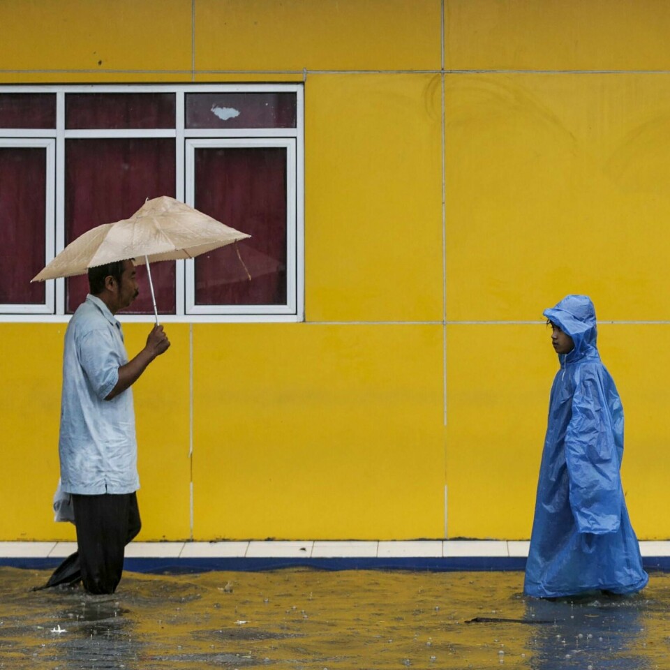 FLOM: En mann og en dame vasser i gatene. Jakarta er rammet av flom.