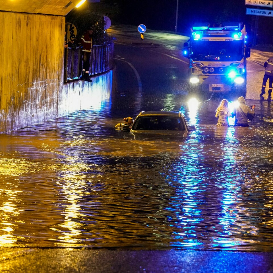 FLOM: En familie måtte reddes ut av en bil på søndag etter den ble dekket av vann. En bil kjørte seg fast i vannmassene i undergangen ved Lørenskog stasjon søndag kveld. Foto: Fredrik Hagen / NTB