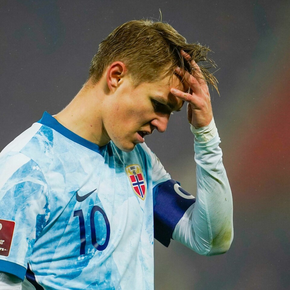 TAP: Martin Ødegaard og Norge måtte vinne mot Nederland. Det klarte de ikke. Bildet er av Martin Ødegaard. Han tar seg til hodet i frustrasjon. Han har på en norsk landslagsdrakt som er blå og hvit. Den er inspirert av en isbre. Han har nummer 10 på drakta og et kapteinsbind på armen.