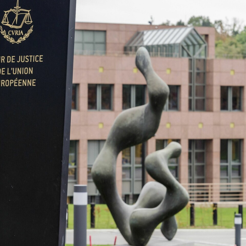 ULOVLIG: EU-domstolen mener Ungarn og Polen bryter lover og regler som alle land i unionen må følge. Bildet er av EU-domstolen i Luxembourg. I forgrunnen er en statue og et skilt om at det er EU-domstolen. I bakgrunnen er et bygg med mur- og glassfasade. Foto: Geert Vanden Wijngaert / AP / NTB