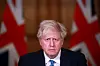 Bildet er av Boris Johnson med et bekymret ansiktsuttrykk. Han har på dress. Det er to britiske flagg i bakgrunnen. De er på hver sin side av ham.