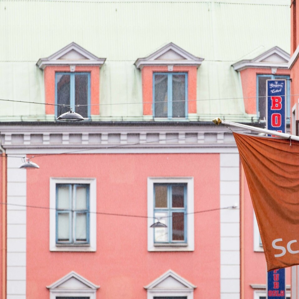 SLITER: De nye reglene mot korona gjør at hotellene sliter. Sjefer på flere av disse sier nå at det kan bli behov for å permittere flere hundre ansatte. Bildet er av et rødt flagg med logoen til hotellkjeden Scandic på. I bakgrunnen er det en annen bygård. Foto: Geir Olsen / NTB