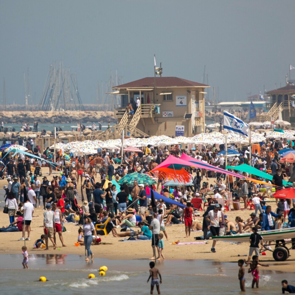 ISRAEL: Den australske mannen har fått forbud mot å reise ut av Israel. Livet begynner å vende tilbake til normaltilværelse i Israel. Bildet er fra Tel Aviv torsdag der folk strømmet til stranden på landets uavhengighetsdag. Foto: Ariel Schalit / AP / NTB
