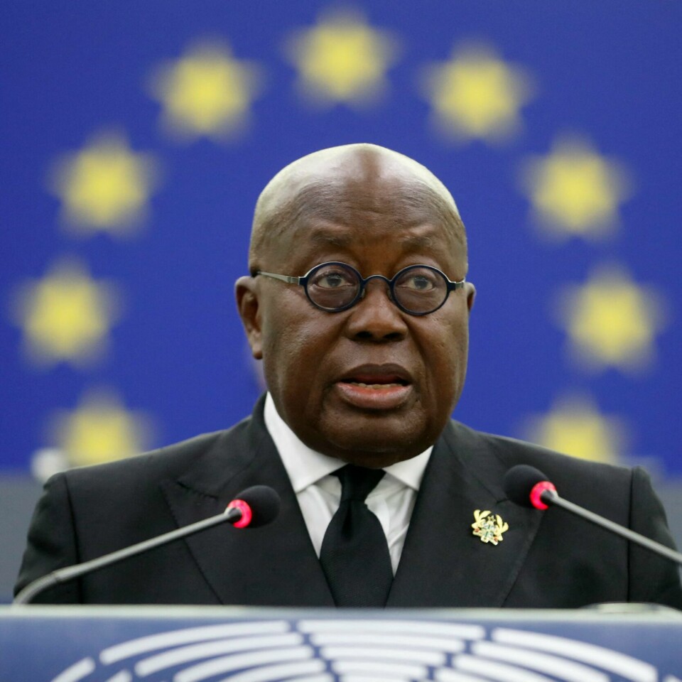 SINT: Nana Akufo-Addo blir sint av at rike land sikrer seg de aller fleste korona-vaksinene. Det gjør at svært få folk i Afrika er vaksinert. Bildet er av Ghanas president Nana Akufo-Addo. Han står bak en blå talerstol. I bakgrunnen er det blå EU-flagget med en ring gule stjerner. Disse omkranser hodet til Akufo-Addo.