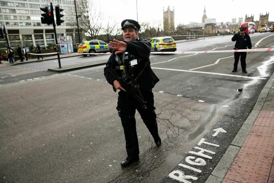 SIKRER: Politiet holder folk unna. De sikrer stedet der en angriper drepte flere personer. Det skjedde nær Parlamentet i London i Storbritannia. Bildet viser en politimann i London som ber folk gå bort.