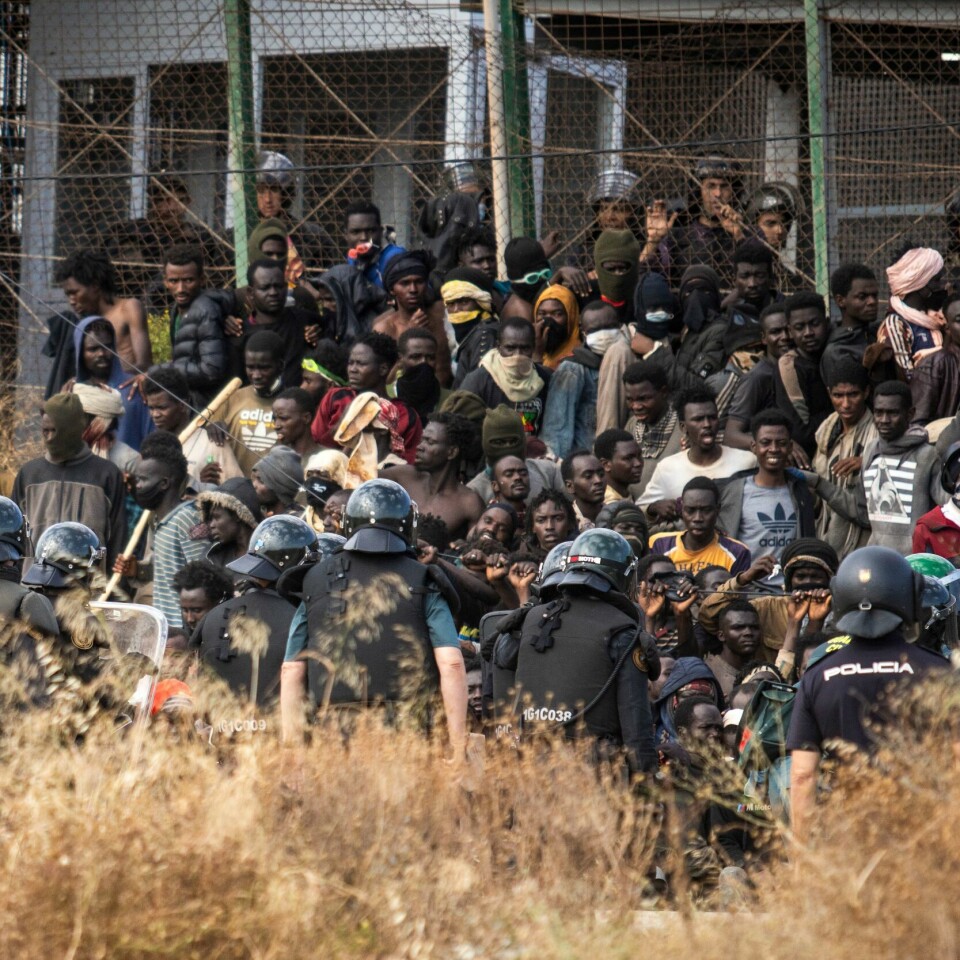 GRENSEN: Rundt 2.000 mennesker prøvde å krysse grensen mellom Marokko og Spania forrige uke. Marokkansk opprørspoliti grep inn. Minst 23 mennesker døde. Bildet viser mennesker ved grensegjerdet. Rundt 2.000 mennesker prøvde å krysse grensen mellom Marokko og Spania forrige uke. Marokkansk opprørspoliti grep inn. Minst 23 mennesker døde.