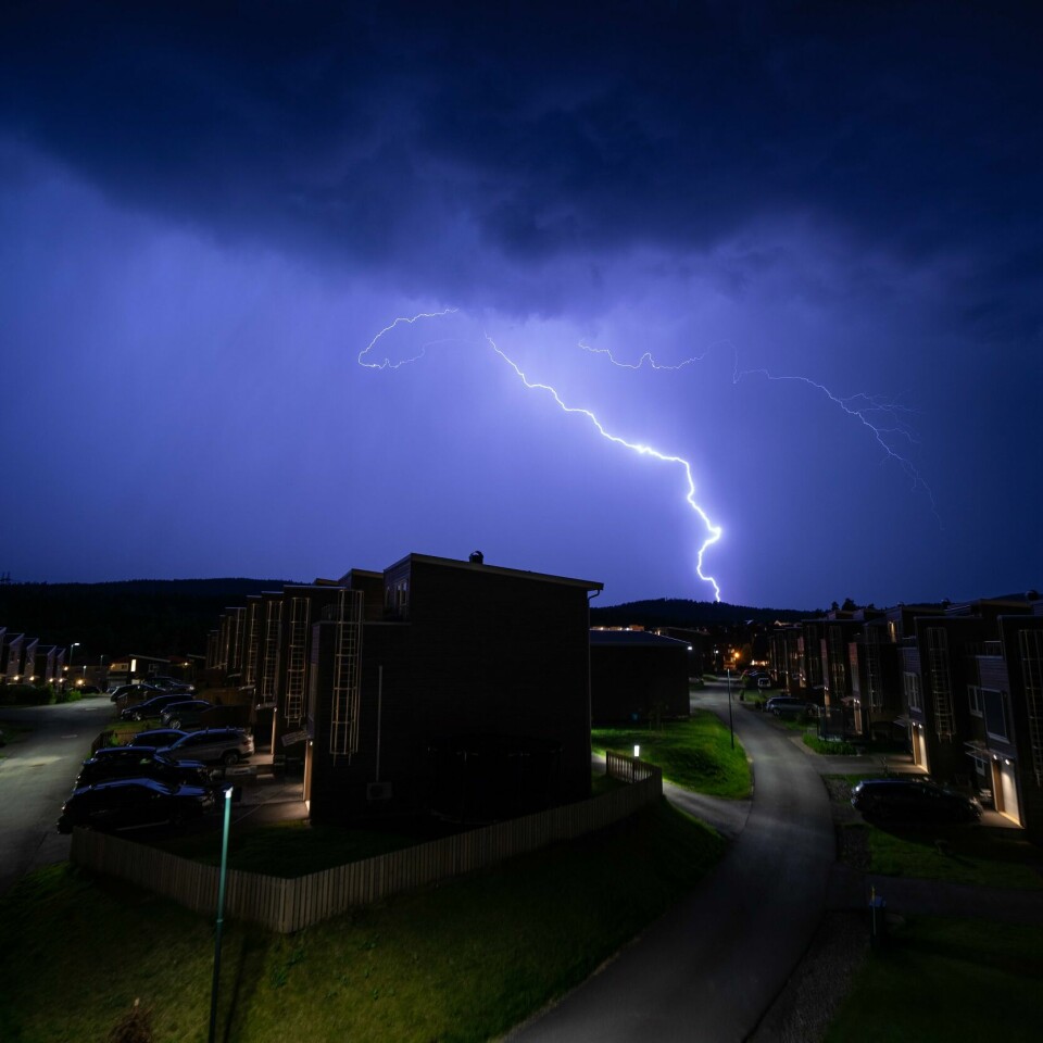 UVÆR: Det kan bli mye uvær på Østlandet og i Øst-Finnmark onsdag. Bildet er av lyn og torden over husrekker. Det er mørke skyer og natt. Foto: Stian Lysberg Solum / NTB