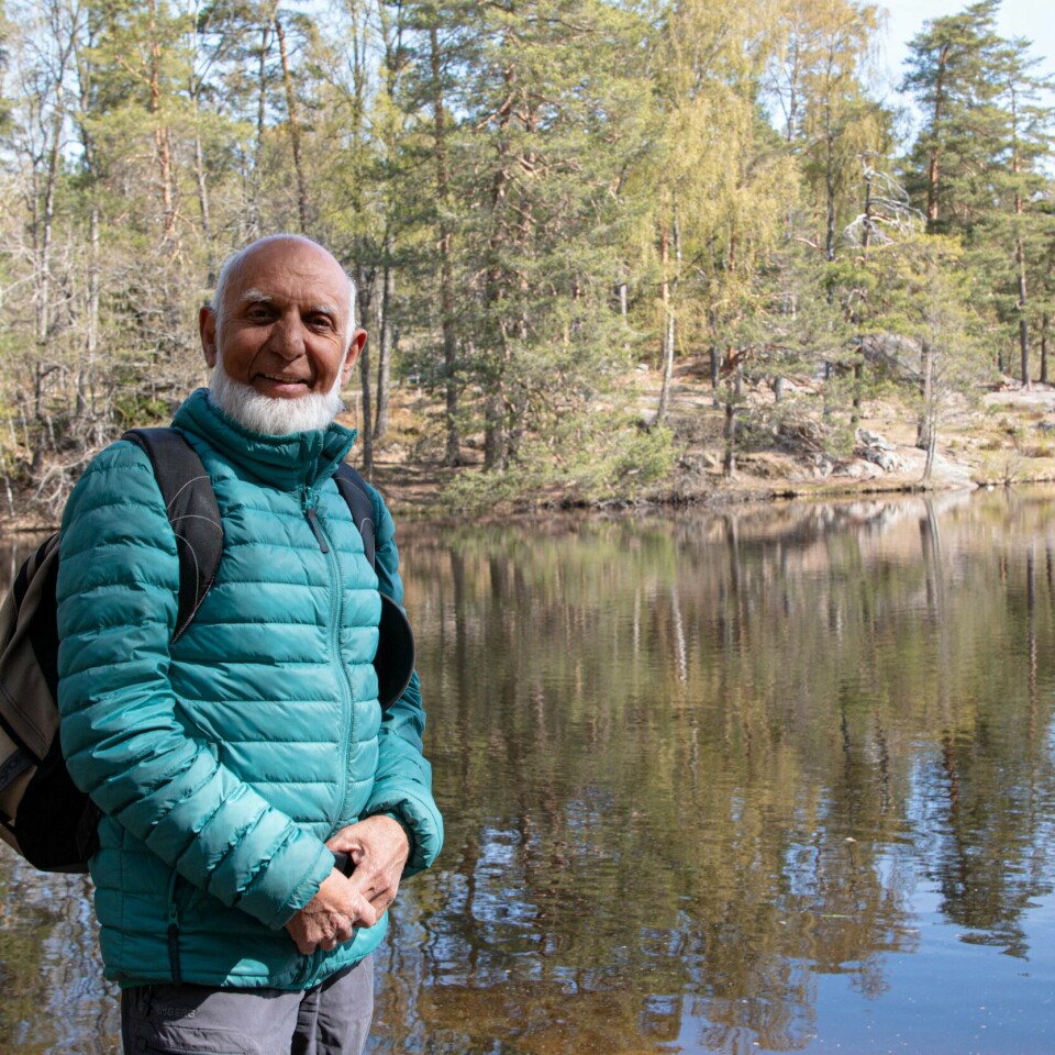TUR: Abdur vil ha med flere innvandrere på tur. Bildet er av Abdur Razzaq. Han er en eldre mann med hvitt skjegg og turklær. Han står ved et vann og i bakgrunnen er det trær. Foto: Petter Johansen Skipperø / Klar Tale