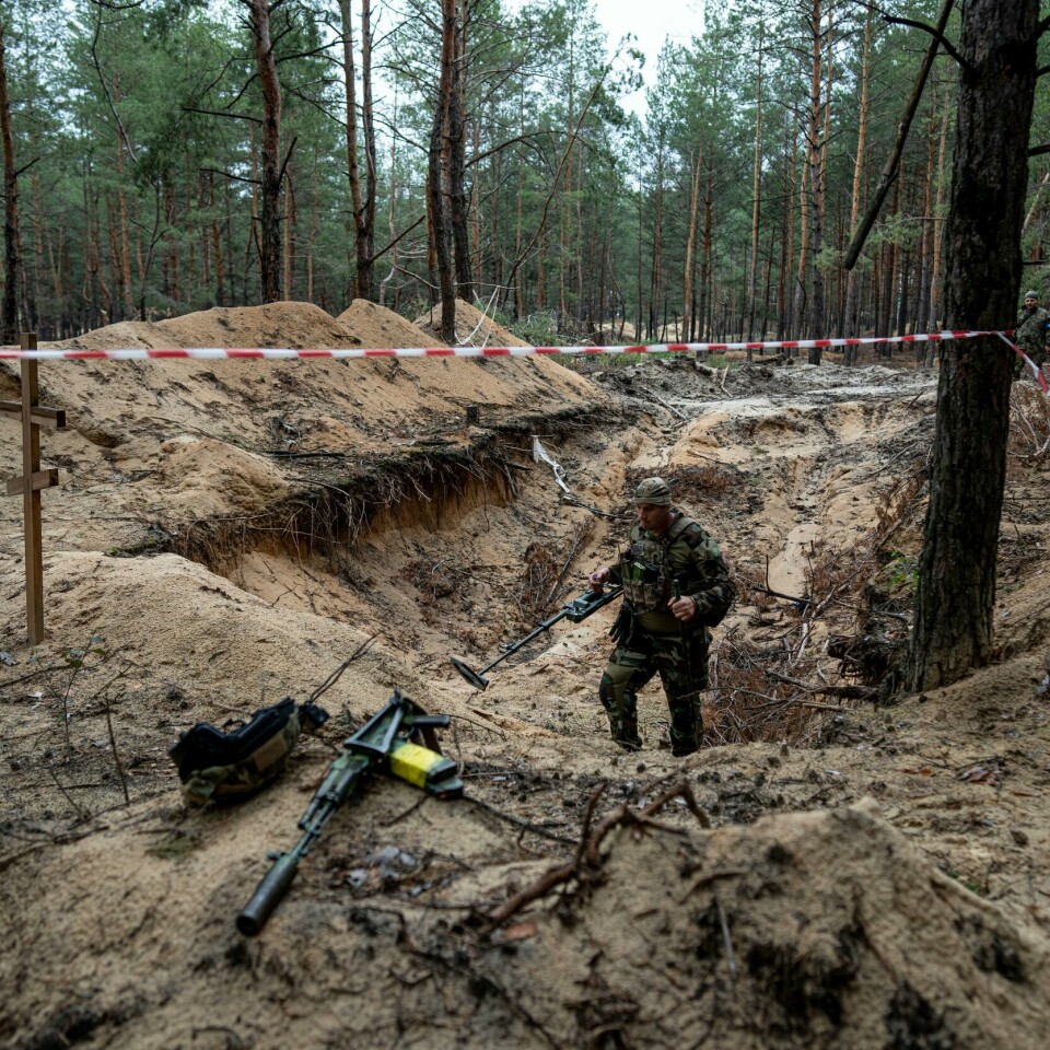 UKRAINA: En ukrainsk soldat. Han bruker metalldetektor for å inspisere en massegraver utenfor Izium. Ukraina nylig tok tilbake kontrollen over Izium. Bildet viser en ukrainsk soldat bruker metalldetektor for å inspisere en massegraver utenfor Izium, som Ukraina nylig tok tilbake kontrollen over.