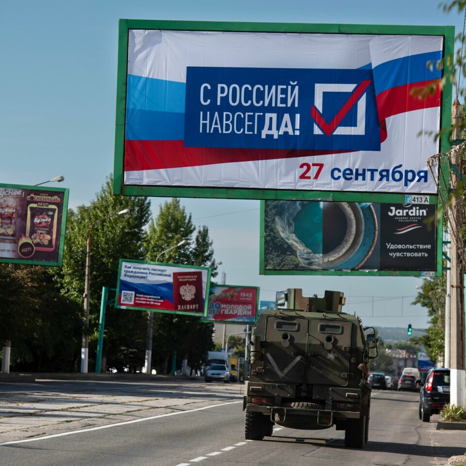 FOLKEAVSTEMNING: Et militærkjøretøy kjører under et skilt med «sammen med Russland for alltid, september 27». Det er før folkeavstemningen i russisk-kontrollerte Luhansk. Et militærkjøretøy kjører under et skilt med «sammen med Russland for alltid, september 27» i forkant av folkeavstemningen i russisk-kontrollerte Luhansk. Foto: AP / NTB