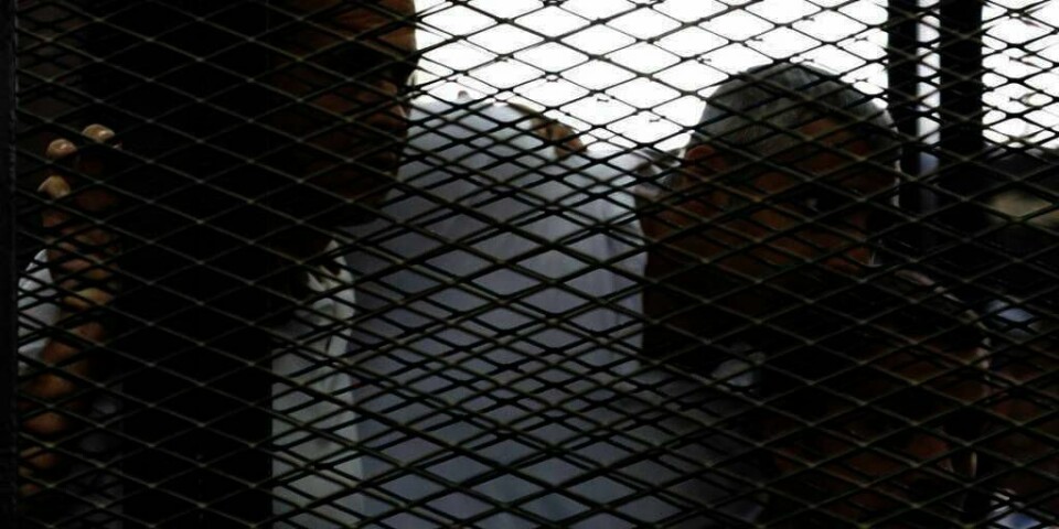 FENGSEL:  De tre journalistene, Peter Greste, Mohamed Fadel Fahmy og Baher Mohamed, sitter i bur i rettssalen i Egypt.