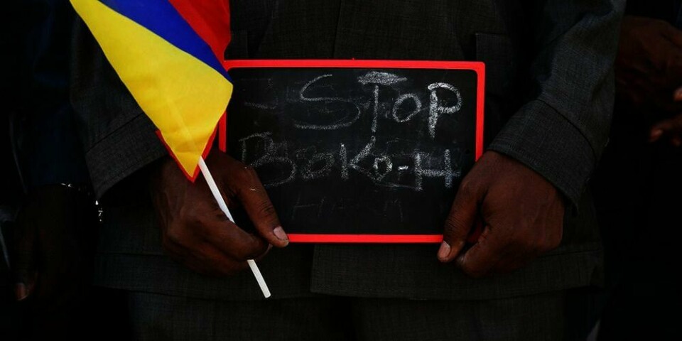 En mann holder et skilt hvor det står stopp Boko Haram. Kamerun vil jobbe sammen med Tsjad og Niger for å stoppe Boko Haram.