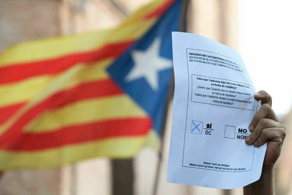 STEMMER: Folk i Catalonia skal svare på ett enkelt spørsmål: Bør Catalonia rive seg løs fra Spania. Bildet viser en hånd som holder opp en stemmeseddel.