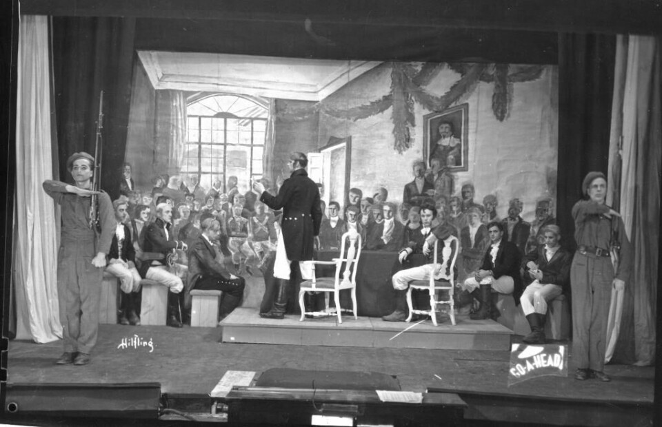 1945: Det var ikke UKA under krigen, men den startet opp igjen i 1945. Bildet er fra revyen det året. Studentene setter i scene det berømte maleriet «Eidsvold 1814». Soldater vokter maleriet. Bildet viser en scene fra revyen «Go ahead» under UKA i 1945.