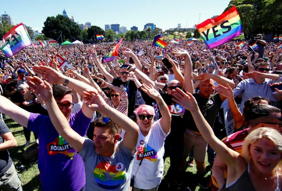 JUBEL: Folk feirer i parken i Sydney i Australia. Bildet viser folk som jubler i en park.