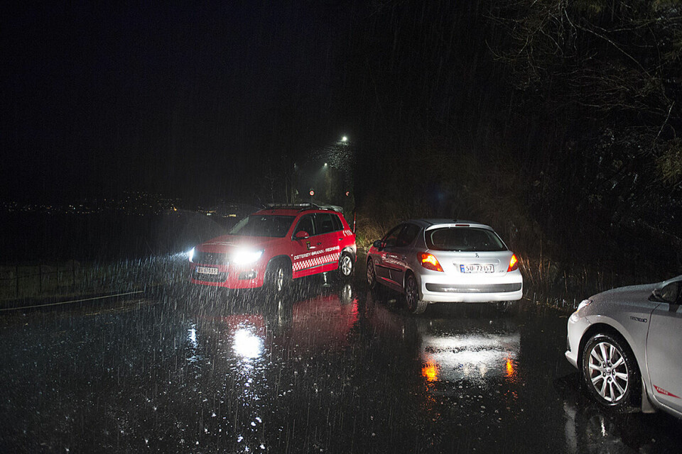 RAS: Et jordras traff et hus på Osterøy i Hordaland. Veien inn til huset på Votlo er stengt. Bildet viser biler på en mørk vei.