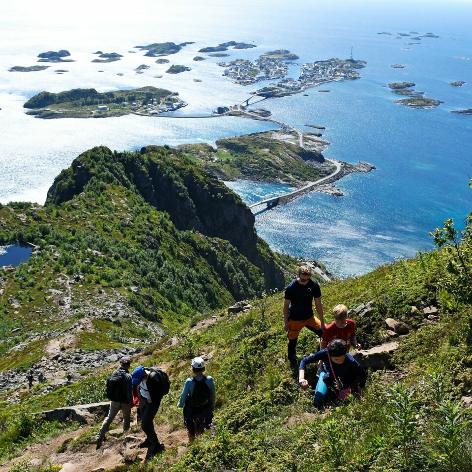 Folk i Norge sier de vil ha en aktiv ferie i sommer. Og de aller fleste vil reise på ferie i Norge. Bildet er av turistr på toppen av Festvågtinden ved Henningsvær i Lofoten. Foto: Rune Stoltz Bertinussen / NTB / NPK