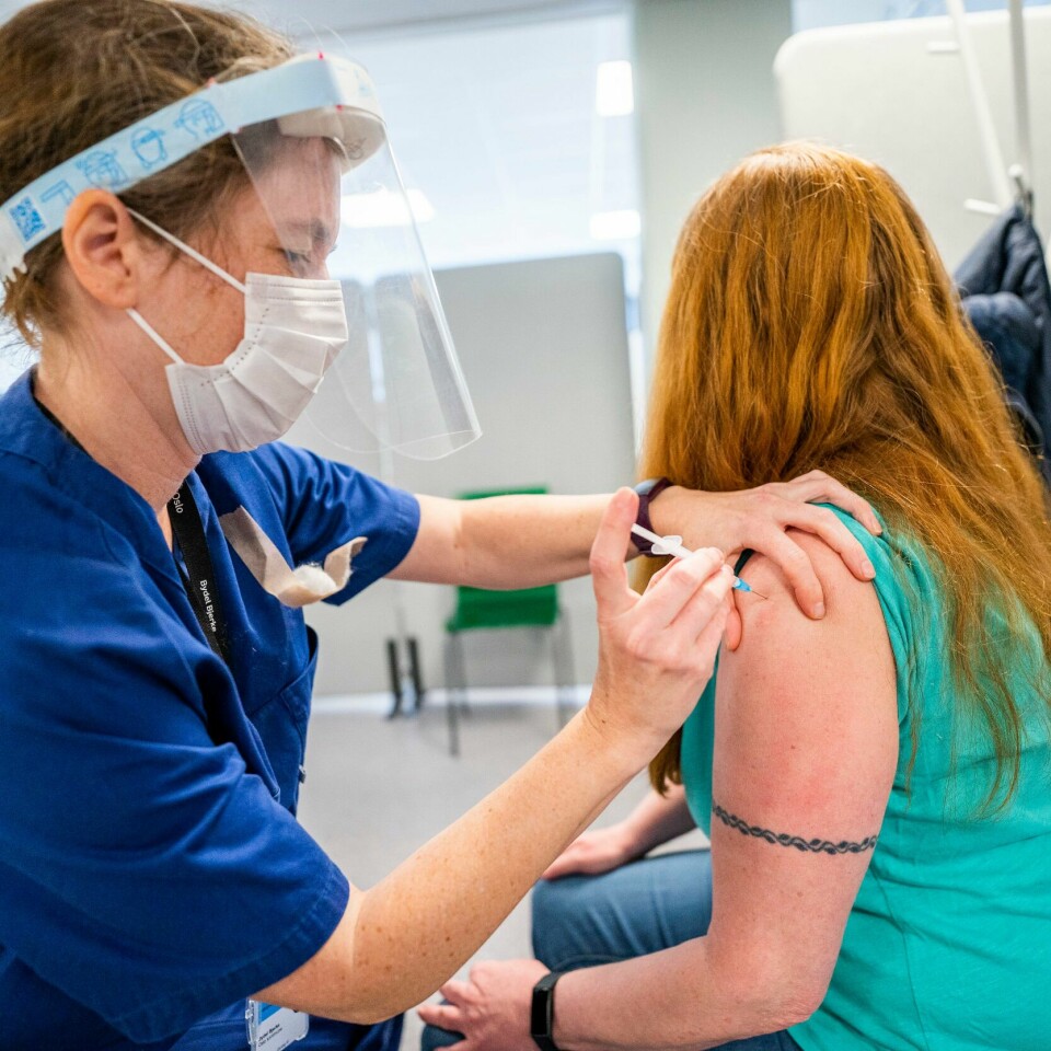 VAKSINE: Noen kvinner kan oppleve at brystene virker større etter vaksinering med Pfizer-vaksinen. Det skyldes trolig at lymfeknutene i armhulen hovner opp, ifølge leger. Sykepleier Åshild Skårland setter vaksinen i Arnesens overarm på vaksinesenteret i Bjerke bydel i Oslo. Dette er hennes første vaksinedose. Over 1 million nordmenn har fått sin første dose av koronavaksine, og i bydel Bjerke har 10.000 innbyggere fått minst en dose. Foto: Håkon Mosvold Larsen / NTB