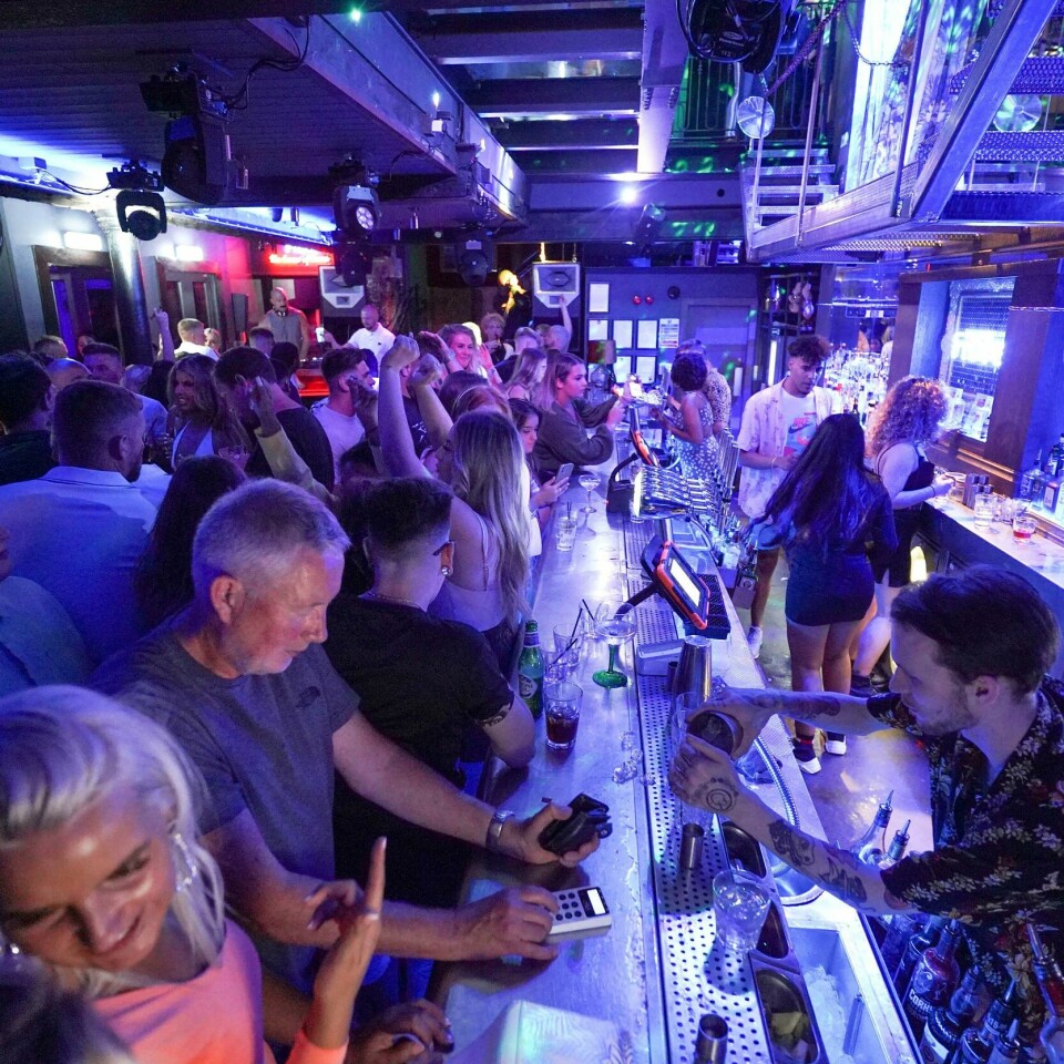 Både eksperter og folk er bekymret over at England har fjernet en del restriksjoner. En full nattklubb med folk som står tett i tett langs baren og skal bestille drikke fra bartenderen.