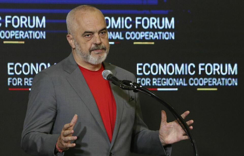 VANSKELIG: Edi Rama sier det var svært vanskelig å hente hjem kvinner og barn fra leirer med fremmedkrigere i Syria. Foto: Boris Grdanoski / AP / NTB Bildet er av Edi Rama som er statsminister i Albania. Han står foran en mørk vegg hvor det står 'Economic forum for regional cooperation' i hvit skrift. Han har på rød trøye og grå dressjakke. Han snakker i en mikrofon foran seg. Han har grått, kort hår og skjegg. Foto: Boris Grdanoski / AP / NTB