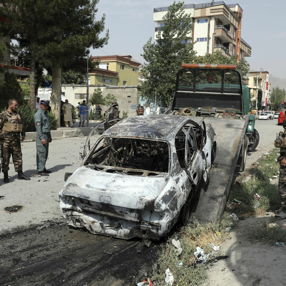 UNE og UDI mener det er for utrygt i Afghanistan til å tvinge noen tilbake nå. Bildet er fra tirsdag. Da ble det skutt raketter mot huset til presidenten. Bildet er av afghanske sikkerhetsstyrker som ser på en ødelagt bil som politiet mener ble brukt i rakettangrepet tirsdag. Foto: AP / NTB
