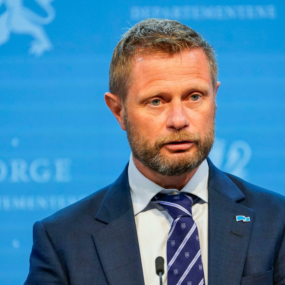 VENTER: Bent Høie sier det er behov for å vente med neste trinn av gjenåpningen. Barn og unge må bli prioritert, sier han. Bildet er av helseminister Bent Høie. Han har på seg skjorte og dress, og står foran en blå vegg. Han har kort hår og skjegg. Foto: Torstein Bøe / NTB