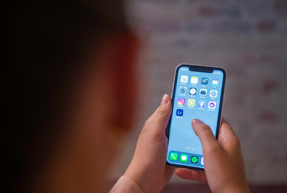 VARSEL: Fra nyttår vil alle nordmenn bli varslet om kriser og ulykker på mobilen. Bildet viser en hånd som holder en mobiltelefon.Foto: Annika Byrde / NTB