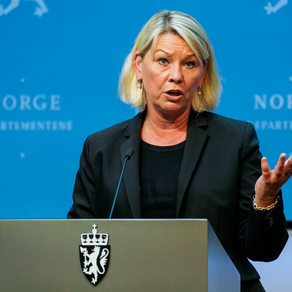 FLERE: Monica Mæland sier flere grupper kan få en sjanse til å søke asyl i Norge. Det gjelder lokalt ansatte i Afghanistan som har jobbet for Norge. Bildet er av Monica Mæland. Hun står foran en blå vegg og bak en talerstol.