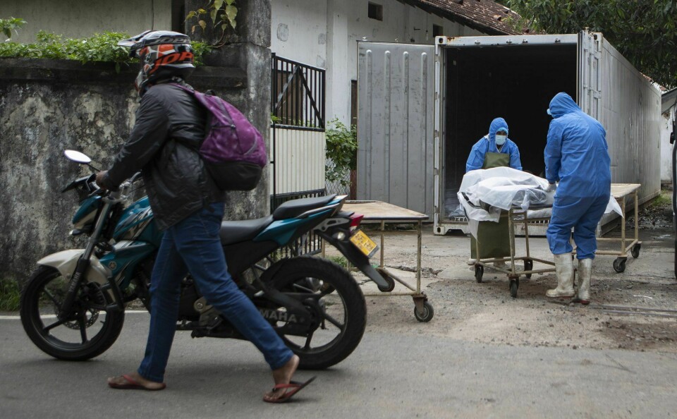 SRI LANKA: Korona-viruset har skapt problemer for Sri Lanka. Men nå har de også problemer med matmangel. Helsearbeidere håndterer en person som er omkommet under koronapandemien i Sri Lankas hovedstad Colombo. Sri Lankas økonomi har falt kraftig under pandemien og tirsdag gikk landets private banker tomme for utenlandsk valuta. Nå innføres det kriselover for omfordeling av mat og trafikanter bes om spare på bruken av drivstoff. Foto: Eranga Jayawardena/ AP/ NTB