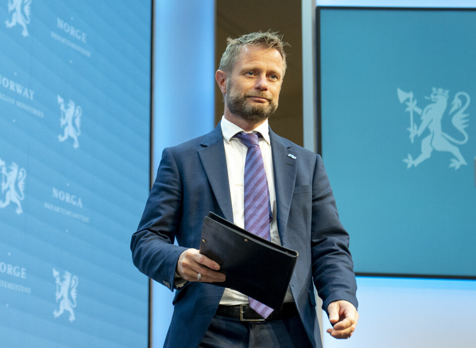 NYTT: Helseminister Bent Høie skal si mer om hva regjeringen gjør med korona. Bildet er av helseminister Bent Høie i dress. Han har blå vegger bak seg, og en dokumentmappe i den ene hånda. Foto: Torstein Bøe / NTB