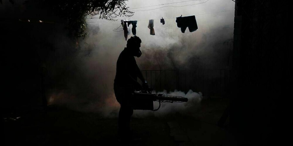 BESKYTTER: En helsearbeider forsøker å beskytte et område i El Salvador fra mygg. Myggene kan blant annet smitte folk med zikavirus.