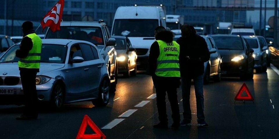 Det er bilkø utenfor en av flyplassene i Paris i Frankrike. Streikende drosjesjåfører sperrer innkjøringen til flyplassen.
