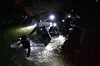 Bildet viser redningsarbeidere inne i en grotta i Thailand. 12 gutter og en fotballtrener har sittet fanget i en grotte i over to uker. Søndag ble fire av guttene reddet ut.