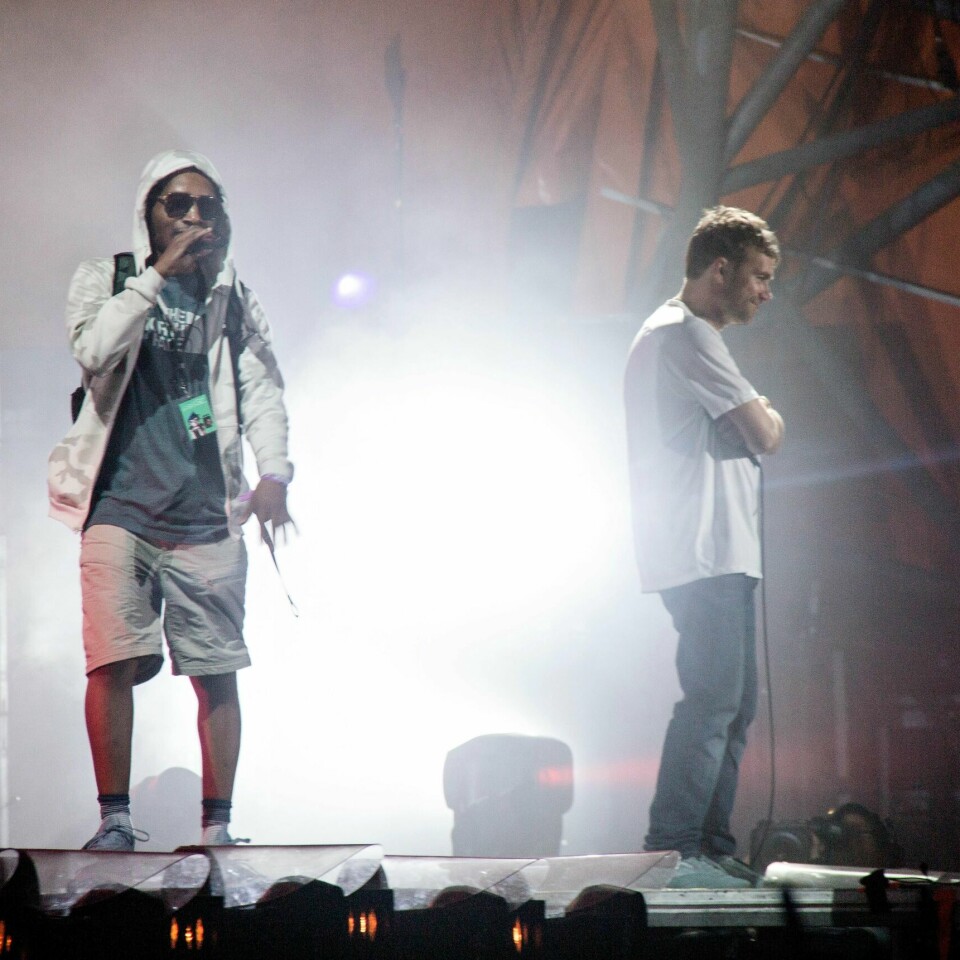 In this July 7, 2018 photo, U.S. rapper Del the Funky Homosapien walks towards the edge of the stage seconds before falling during the performance of British band Gorillaz at the Orange Stage during the Roskilde Festival in Roskilde, Denmark. (Erling Brodersen/Ritzau Scanpix via AP)