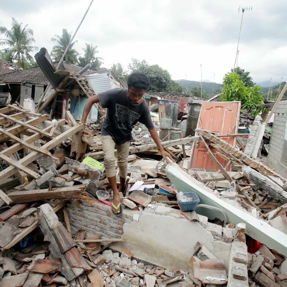 A man walks through debris from Sunday's earthquake in West Lombok, Indonesia, Saturday, Aug. 11, 2018. Scientist say the powerful Indonesia earthquake that killed more than 300 people lifted the island it struck by as much as 25 centimeters (10 inches). (AP Photo/Firdia Lisnawati)