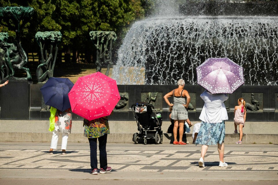 VARMT: Det var varmt i Vigelandsparken i sommer. Turister brukte paraplyer for å beskytte seg mot sola.