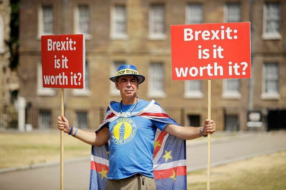 PROTEST: En mann bærer en plakat med ordene «Brexit: er det verdt det?». Han protesterer utenfor parlamentet i London i Storbritannia.