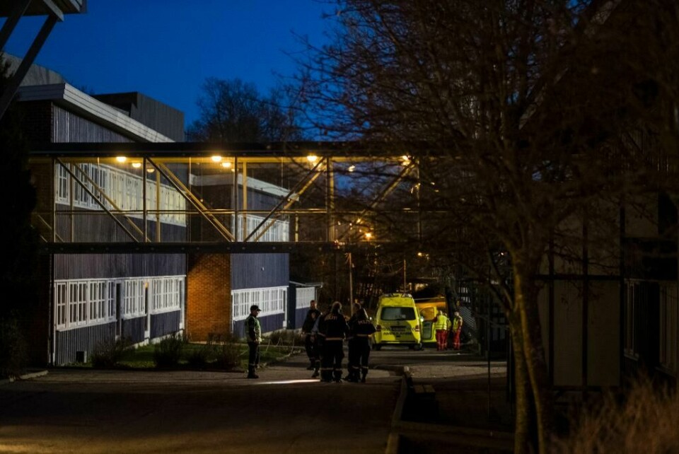 DRAP: Her ble to mennesker drept i desember i fjor. En 16 år gammel gutt har innrømmet drapene. Bildet viser politifolk under en gangbru fra én skolebygning til en annen. Lenger bak står det en ambulanse. Det er mørkt.