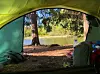 Bildet viser utsikten medvann og skog fra innsiden av teltet. Dette synet kan møte deg når du våkner etter en natt i naturen.