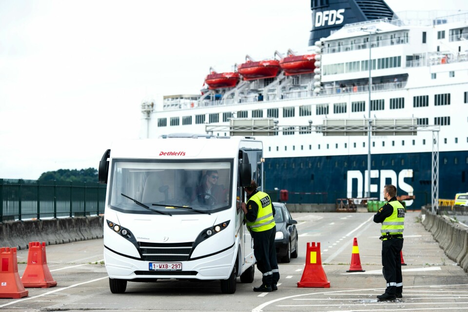 DANSKEBÅTEN: Det kom også mange turister med danskebåten til DFDS. 193 biler var ombord. Norske tollere snakker med en sjåfør i en bobil. Bildet er fra havna i Oslo. I bakgrunnen er danskebåten til DFDS. To tollere er i forgrunnen av bildet. En snakker med sjåføren av en campingbil.
