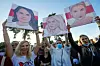 People hold portraits of Svetlana Tikhanovskaya, candidate for the presidential elections, left, wife of non-registered candidate Valery Tsepkalo, Veronika Tsepkalo, centre, Maria Kolesnikova, a representative of Viktor Babariko, right, during a meeting in Borisov, Belarus, Thursday, July 23, 2020. The longtime leader of Belarus President Alexander Lukashenko warned Thursday that Western media could be expelled from the country over what he described as their 'tendentious' coverage of the presidential election next month in which he is seeking a sixth term. The presidential election in Belarus is scheduled for August 9, 2020. (AP Photo/Sergei Grits)