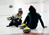 To flyktninger fra Kurdistan ler mens de prøver curling.