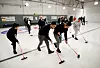 Guttene fra en afghansk familie prøver seg med curling-kost.