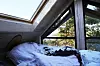 Bildet viser soverommet med takvinduer i trehytta.