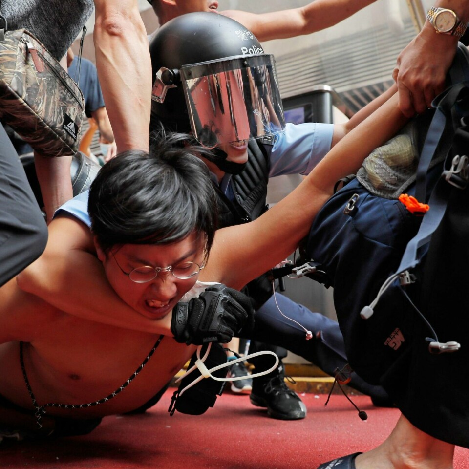 SLÅSSKAMP: Demonstranter har slåss med folk som støtter Kina. Bildet er fra lørdag. Da var det en slåsskamp i Hongkong. Her tar politiet kontroll over en mann.